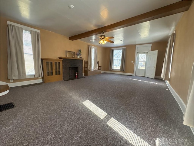 unfurnished living room featuring beam ceiling, visible vents, a healthy amount of sunlight, and baseboards