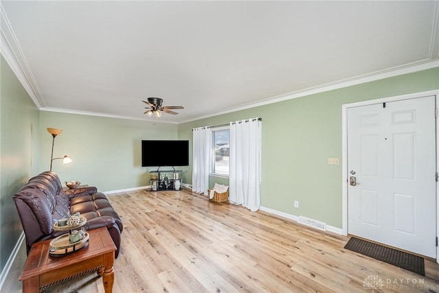 living area with ornamental molding, light wood finished floors, and baseboards