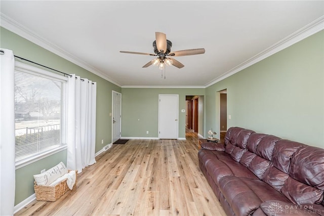 living area with light wood finished floors, baseboards, ornamental molding, and ceiling fan