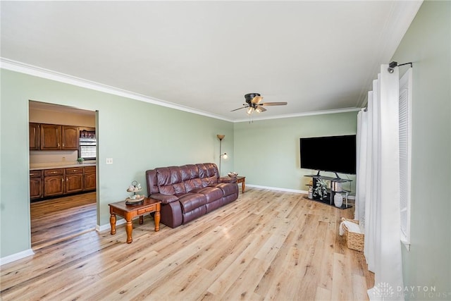 living room with ornamental molding, light wood finished floors, and baseboards