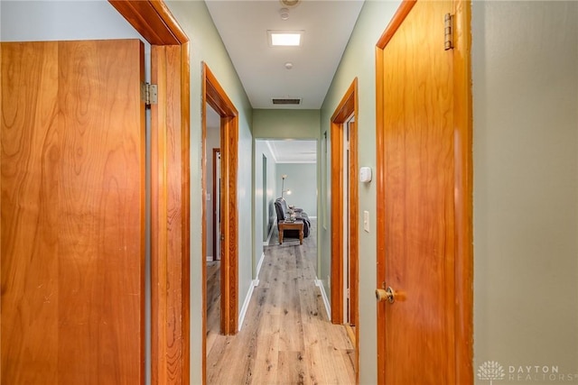 hallway featuring light wood-type flooring and visible vents