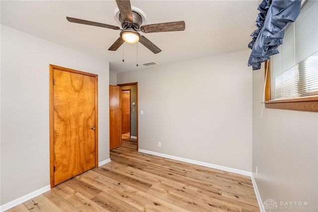 unfurnished bedroom with baseboards, visible vents, a ceiling fan, light wood-type flooring, and a closet