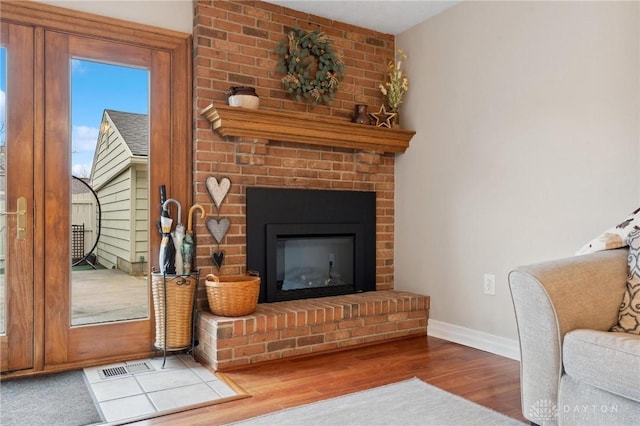 7789 Thomas Jefferson Ln, Centerville, OH 45459 - living area with baseboards, visible vents, wood finished floors, and a fireplace