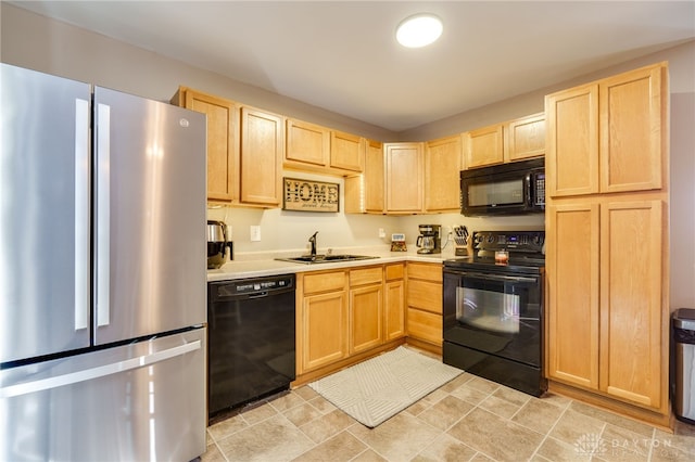 kitchen featuring light brown cabinetry, sink, and black appliances