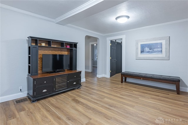 living room with hardwood / wood-style flooring, ornamental molding, a barn door, and a textured ceiling