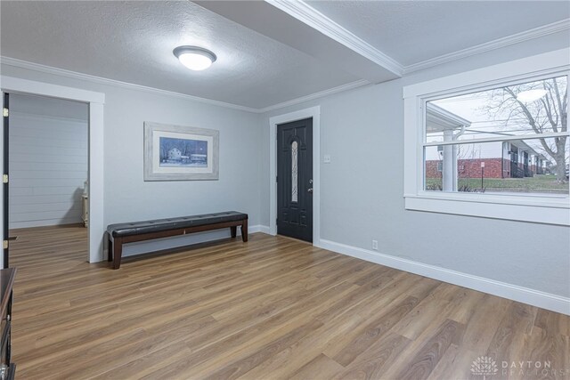 entrance foyer featuring ornamental molding, hardwood / wood-style floors, and a textured ceiling