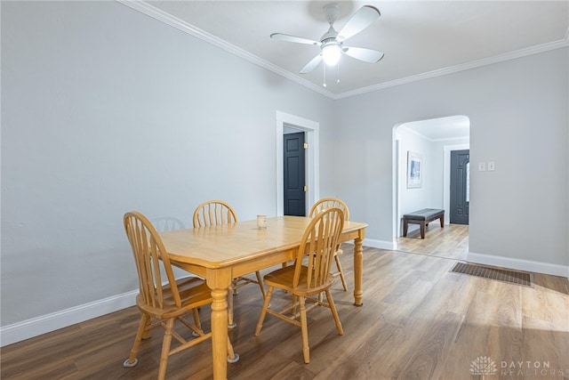 dining room with hardwood / wood-style floors, crown molding, and ceiling fan