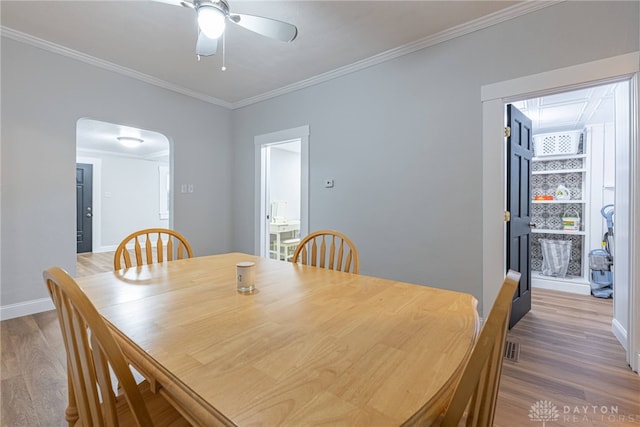 dining space featuring ornamental molding, ceiling fan, and light wood-type flooring