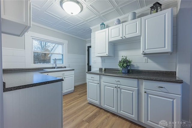 kitchen featuring sink, white cabinets, and light hardwood / wood-style flooring