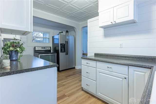 kitchen with white cabinetry, appliances with stainless steel finishes, ornamental molding, and light wood-type flooring