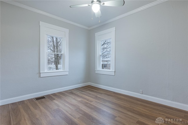 empty room featuring hardwood / wood-style floors, ornamental molding, a wealth of natural light, and ceiling fan