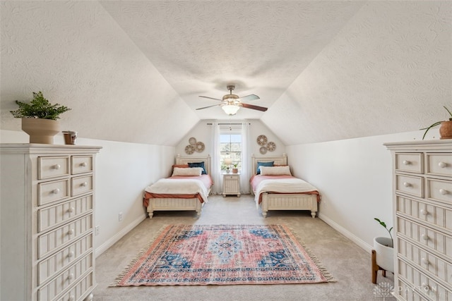 carpeted bedroom featuring baseboards, a textured ceiling, ceiling fan, and vaulted ceiling