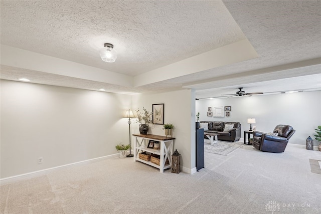 interior space with carpet floors, baseboards, a ceiling fan, and a textured ceiling