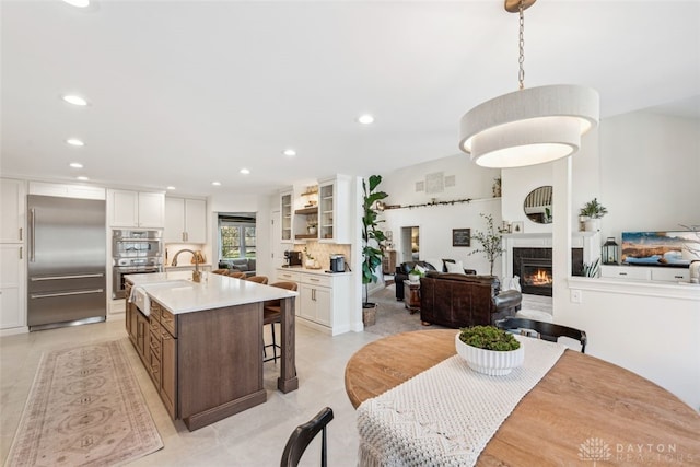 dining area featuring recessed lighting, a lit fireplace, and light tile patterned floors