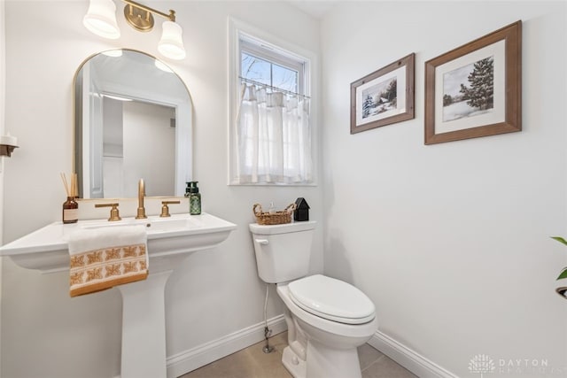 bathroom with baseboards and toilet