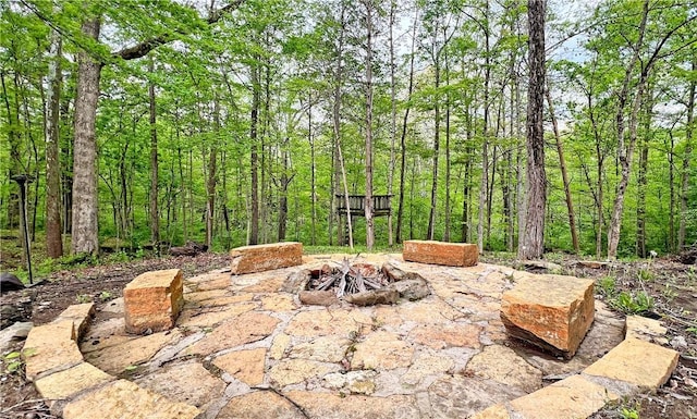 view of patio / terrace featuring a fire pit and a forest view