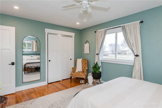 bedroom with hardwood / wood-style floors, ceiling fan, and a closet