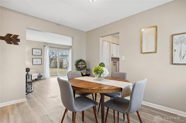 dining space with light hardwood / wood-style floors