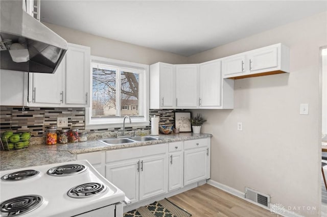 kitchen featuring electric stove, sink, tasteful backsplash, extractor fan, and white cabinets