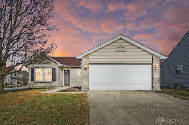 single story home featuring a yard and a garage