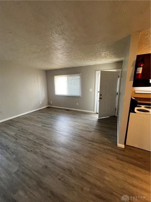 unfurnished living room featuring baseboards, a textured ceiling, and dark wood finished floors