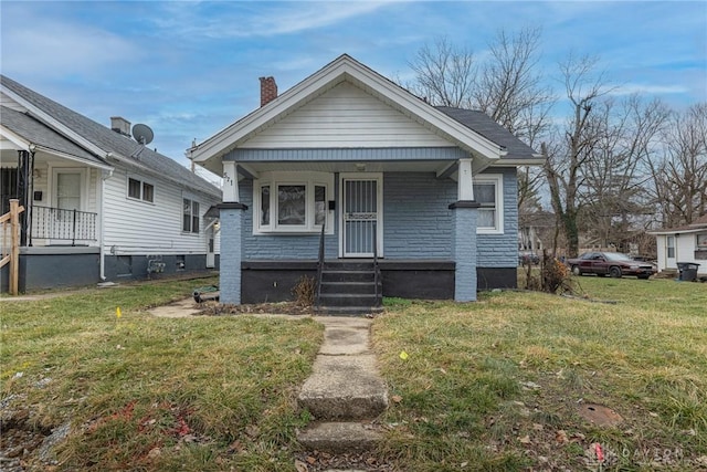 bungalow-style home with covered porch and a front yard