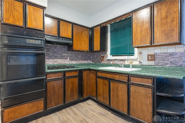 kitchen with sink, oven, backsplash, stainless steel gas cooktop, and light wood-type flooring