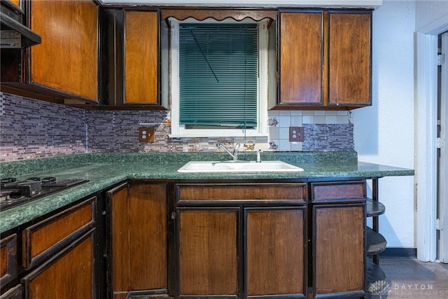 kitchen with backsplash, black gas stovetop, sink, and exhaust hood