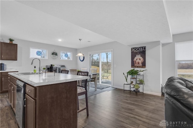1605 Ashbury Ct, Franklin, OH 45005 - kitchen featuring a breakfast bar area, light countertops, stainless steel dishwasher, open floor plan, and a sink