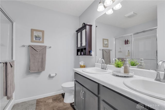 bathroom with vanity, an enclosed shower, and toilet