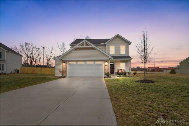 view of front of property with concrete driveway, a front lawn, fence, and brick siding