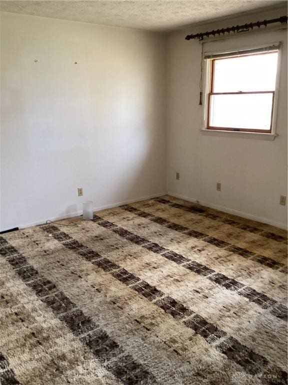 carpeted spare room with a textured ceiling