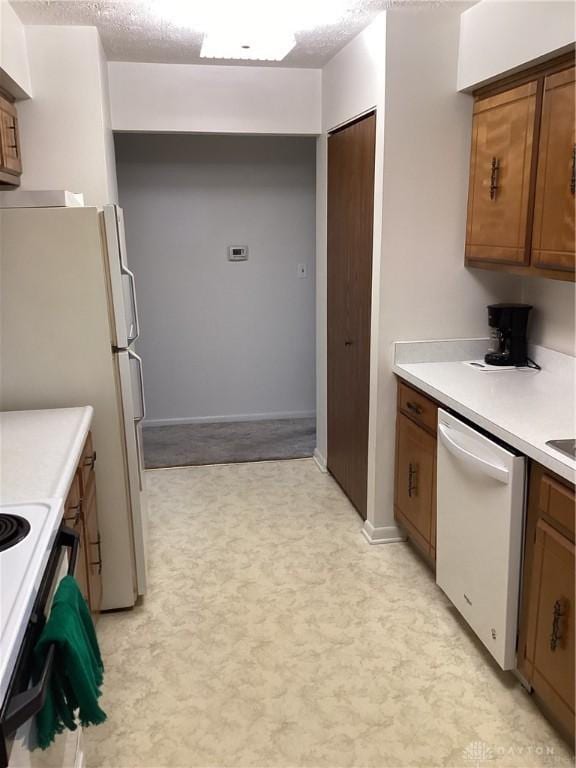 kitchen with white appliances and a textured ceiling