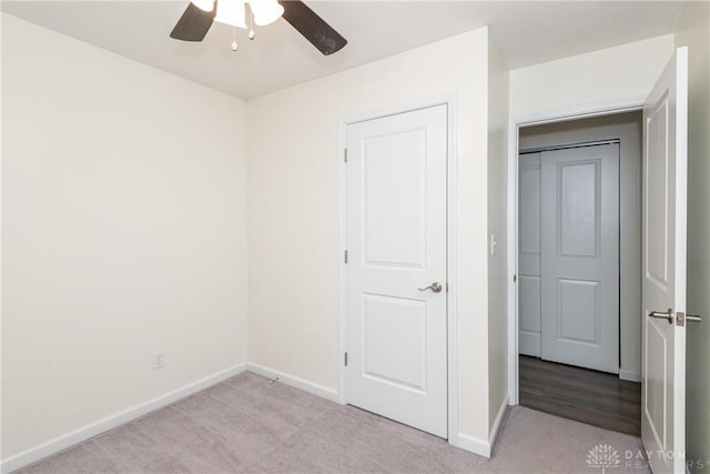 unfurnished bedroom with light colored carpet and ceiling fan