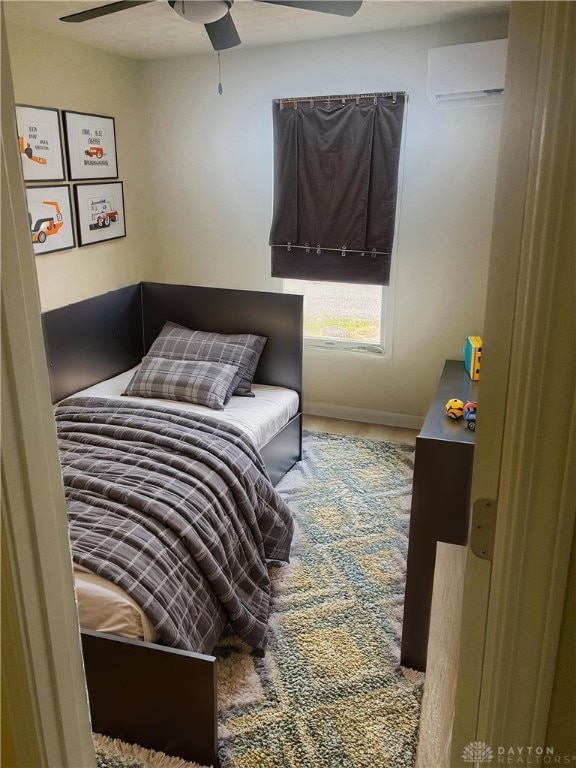 bedroom featuring an AC wall unit and ceiling fan