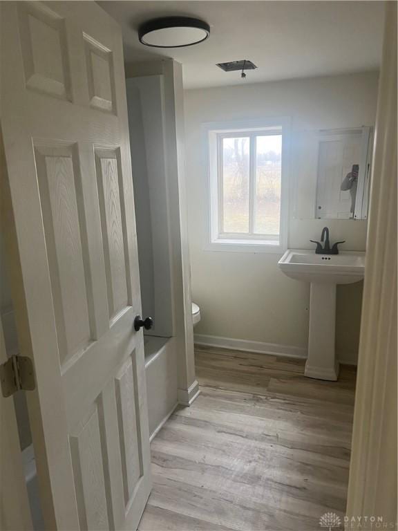 bathroom with hardwood / wood-style floors and toilet