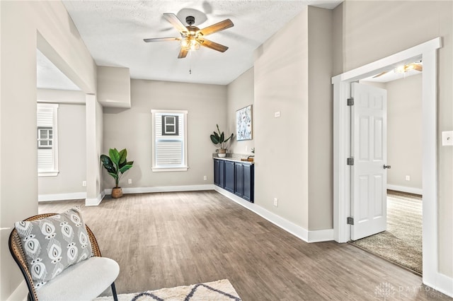 living area featuring baseboards and wood finished floors