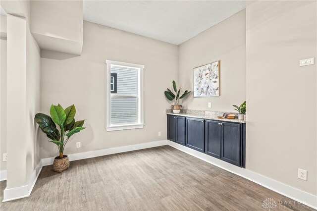 unfurnished room featuring light wood-type flooring and baseboards