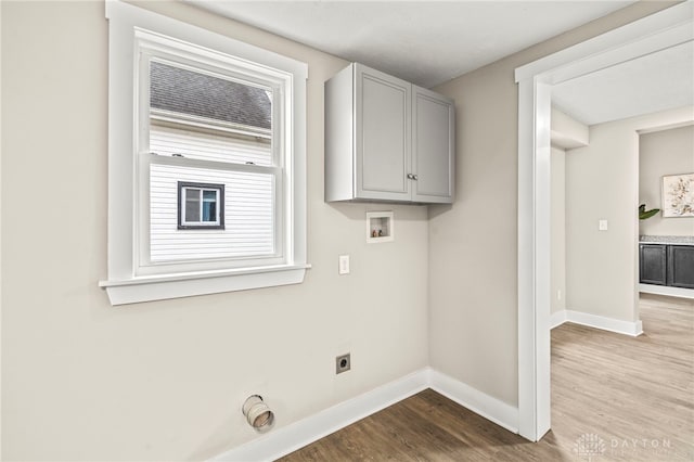 laundry area featuring hookup for a washing machine, cabinet space, light wood-style floors, hookup for an electric dryer, and baseboards