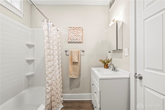 full bath with baseboards, visible vents, wood finished floors, shower / bath combination with curtain, and vanity