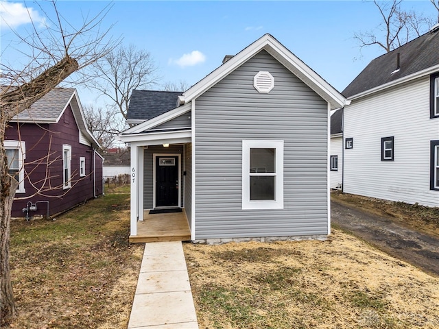 view of front of property with a front lawn and roof with shingles