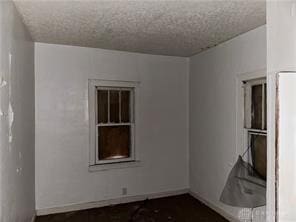 unfurnished room with a textured ceiling