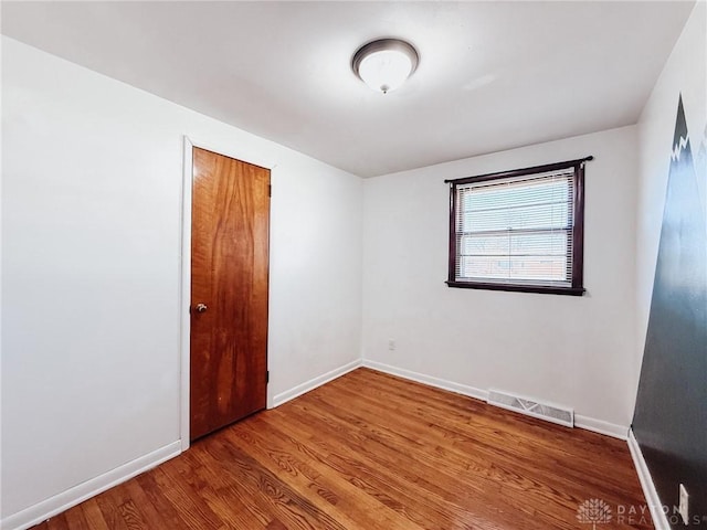 unfurnished room with wood-type flooring