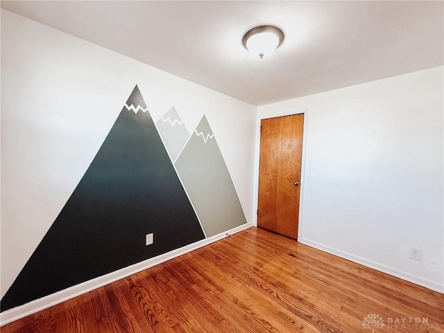 unfurnished room with wood-type flooring