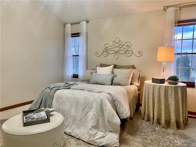 bedroom featuring lofted ceiling and multiple windows