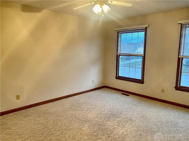 unfurnished room featuring ceiling fan and carpet