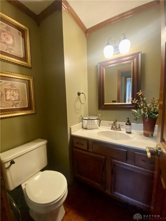 bathroom featuring vanity, ornamental molding, hardwood / wood-style floors, and toilet