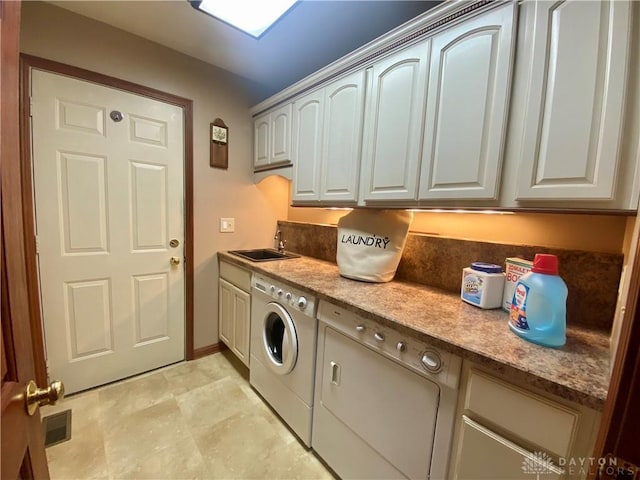 laundry room featuring cabinets, sink, and washer and clothes dryer