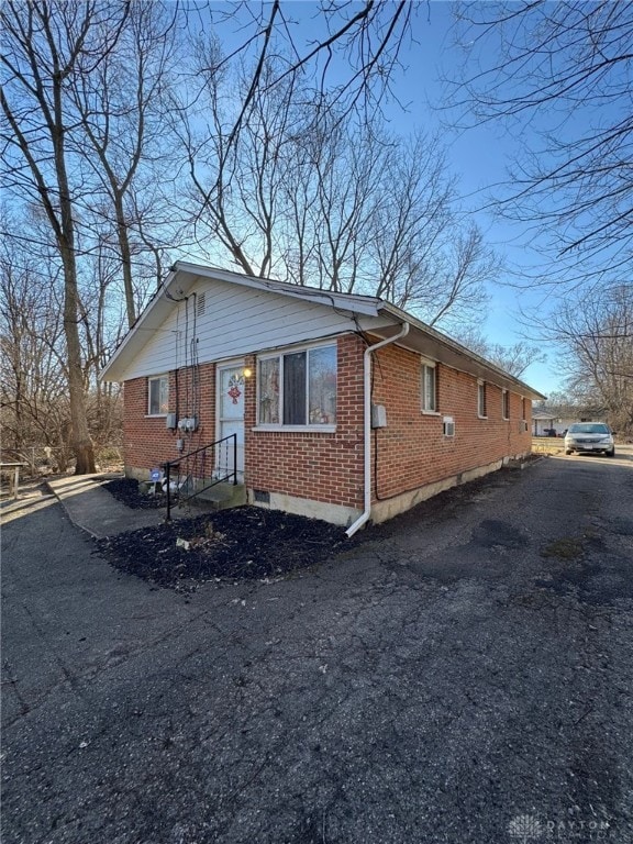 view of front of house featuring driveway and brick siding