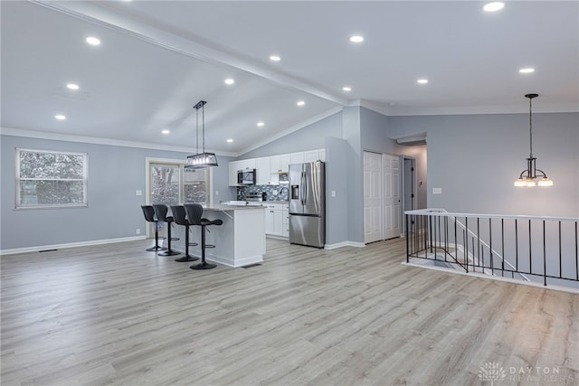 kitchen featuring a kitchen breakfast bar, backsplash, baseboards, stainless steel appliances, and white cabinetry